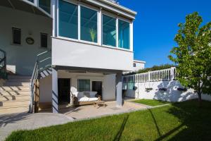 a white house with a porch with a couch at Apartments Lili Flora in Zadar