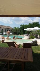 una piscina con mesa y sillas y gente en el agua en Mandalay Lodge & Resort Senigallia, en Senigallia