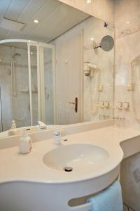 a bathroom with a sink, toilet and bathtub at Hotel Garni "Am Ellinger Tor" in Weißenburg in Bayern