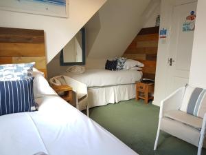 a attic room with two beds and a chair at Beach Lodge in Bournemouth