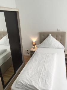 um quarto com um espelho ao lado de uma cama em Hotel Central Hannover em Hanôver