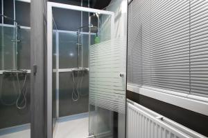 a bathroom with a shower stall and a glass door at Galaxy Pod Hostel in Reykjavík