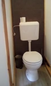 baño con aseo blanco en una habitación en farmglamping Planika - Encijan, en Hraše