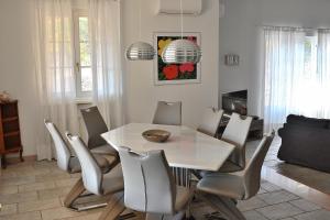 une salle à manger avec une table et des chaises blanches dans l'établissement Villa Gasco With Pool, à Lazise