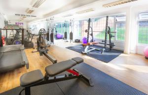 - une salle de sport avec plusieurs tapis de course et vélos d'exercice dans l'établissement De Rougemont Manor, à Brentwood