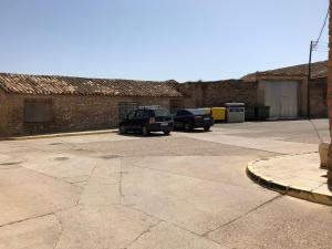 two cars are parked in a parking lot at Casa el Sol in Lumpiaque
