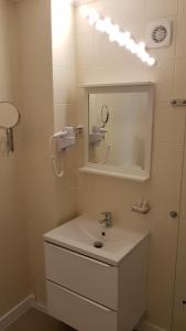 een witte badkamer met een wastafel en een spiegel bij Hotel Mic in Boekarest