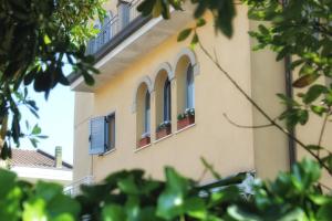a building with two windows with flowers in them at Villa Carina in Massa