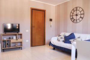 a living room with a couch and a clock on the wall at Villa Carina in Massa