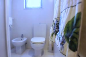 a white bathroom with a toilet and a sink at Villa Carina in Massa