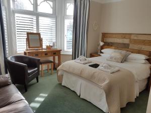 a bedroom with a bed and a desk and a chair at Beach Lodge in Bournemouth