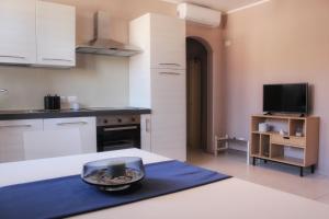 a kitchen with white cabinets and a blue counter top at Villa Carina in Massa