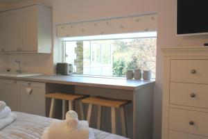 a kitchen with a window and a counter with stools at Ashford house 'The Snug' private hot tub in Fylingthorpe