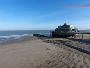 a view of a beach with a pier and the ocean at Hotel Riant-Séjour by WP Hotels in Blankenberge