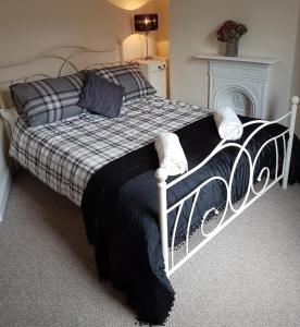a bedroom with a bed with a black and white comforter at No7 Agar Street in York