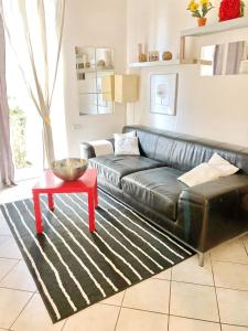 a living room with a black leather couch and a red table at Apartment With Garden in Lucca