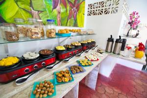 bufet z wieloma różnymi rodzajami żywności w obiekcie Pousada Lua Cheia w mieście Praia do Frances