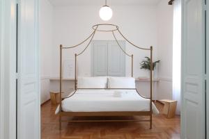 sypialnia z łóżkiem z metalowym baldachimem i białą pościelą w obiekcie Live in Athens, THISEIO Historic House w Atenach