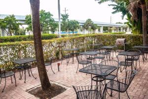 a patio area with tables, chairs and umbrellas at Gables Inn in Miami