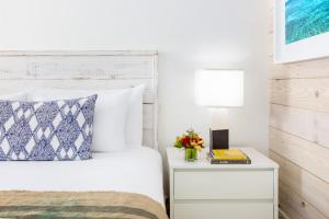 1 dormitorio con 1 cama y mesita de noche con lámpara en The Gates Hotel Key West en Cayo Hueso