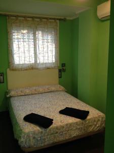 sypialnia z łóżkiem z dwoma czarnymi poduszkami w obiekcie Apartamento Cala Blanca w mieście Gandía
