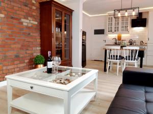 salon z białym stolikiem kawowym i kieliszkami do wina w obiekcie Sea Apartment 150m do morza w Gdańsku