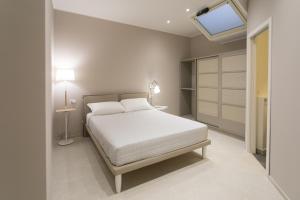 a bedroom with a white bed and a skylight at Ortigia Casa Fab in Syracuse
