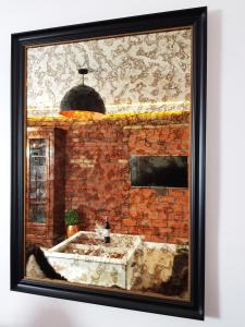 a framed picture of a bathroom with a brick wall at Sea Apartment 150m do morza in Gdańsk