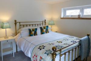 a bedroom with a bed and two lamps and a window at Urquhart Bay Croft in Drumnadrochit