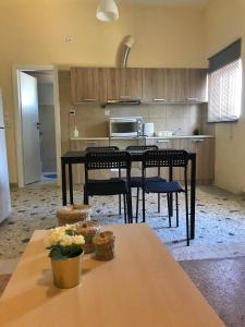 a kitchen with a table and chairs in a room at Sunshine's house near the beach, 10 min from the airport in Artemida