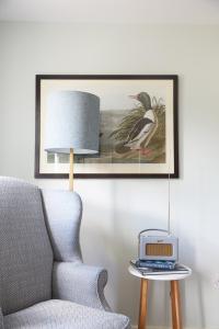 a chair and a table with a lamp and a clock at The Pheasant Inn in Hungerford