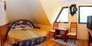 a bedroom with a bed and a table and chairs at Gościnny Dworek in Pobierowo