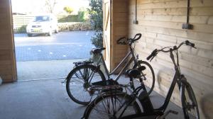 Deux vélos sont garés à côté d'un garage. dans l'établissement Hotel Restaurant Anno Nu, à Oostkapelle