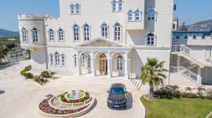 a car parked in front of a large building at Hotel Belagrita in Berat