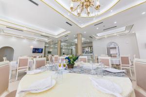 a large room with a table with white chairs and a chandelier at Hotel Belagrita in Berat