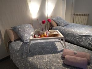 ein Schlafzimmer mit einem Bett und einem Tisch mit Blumen darauf in der Unterkunft COZY APARTAMENT 10 MINUTES FROM THE HEART OF MADRID in Madrid