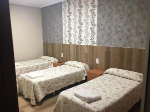 a room with three beds and a wall with patterns at Pensión Blanquita in Logroño +7 photos