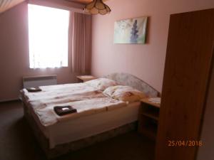 Dormitorio pequeño con cama y ventana en Penzion Oliver en Horní Planá