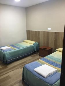 ログローニョにあるPensión Blanquitaのベッド2台が備わるウッドフロアの客室です。