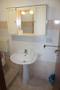 ein Bad mit einem Waschbecken und einem Spiegel in der Unterkunft Casale Corcella in Scopello