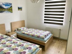 two twin beds in a room with a window at Ferienwohnung Villa Seeblick in Bodensdorf