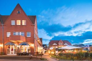 a city street with a building and tables and a building at Seeblick Genuss und Spa Resort Amrum in Norddorf