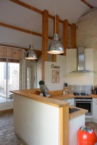 a kitchen with white cabinets and a counter top at Le Clos Millot in Beaune