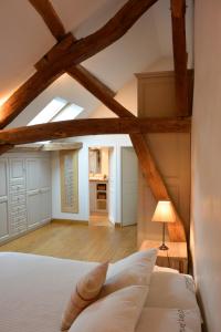 a bedroom with a white bed with wooden beams at Le Clos Millot in Beaune