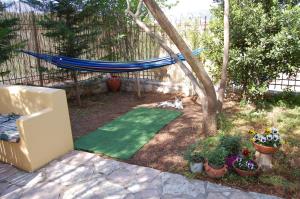 a backyard with a hammock and a dog in a yard at Marianna Holiday Home in Nafplio