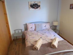 een slaapkamer met een bed met twee kussens erop bij Farraline Court in Inverness