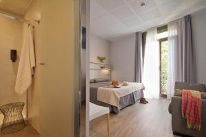 a room with a bed and a table and a window at Hostal Benidorm in Barcelona