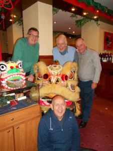 a group of men standing next to a table with masks at Garden Hotel in Bangor