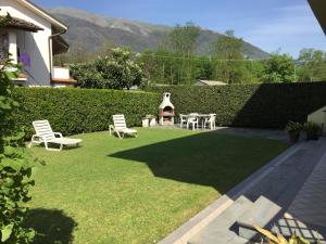 a yard with two chairs and a fire place at Villa Lorenzo primo piano in Camaiore