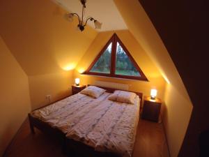 a bedroom with a bed with a large window at Willa Pawlikowskich in Poronin